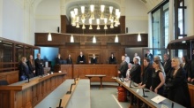 Bei der Fortsetzung der Mordprozess gegen einen Palliativmediziner stehen die Strafverteidiger (l) und die Nebenkläger (r) im Gerichtssaal. Foto: Soeren Stache/dpa