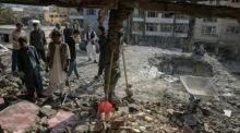 Menschen begutachten in Kabul ein bei mutmaßlichen pakistanischen Luftangriffen zerstörtes Gebäude neben einer Schule. Foto: EPA/Samiullah Popal