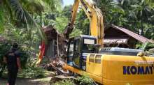 Ein Bagger beginnt mit dem Abriss eines illegal errichteten Gebäudes im Waldschutzgebiet am Nui Beach auf Phuket. Bild: Department of National Parks, Wildlife and Plant Conservation (DNP)