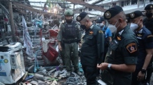 Thailands Nationaler Polizeichef Damrongsak Kittiprapas (M.) inspiziert den Explosionsort nach einem Autobombenanschlag auf ein Gebäude, in dem Polizeibeamte untergebracht sind. Foto: epa/Royal Thai Police