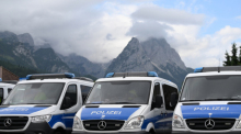 Polizei Mannschaftswägen parken vor Bergkulisse. Der G7-Gipfel ist vom 26. bis 28. Juni 2022 auf Schloss Elmau geplant. Foto: Angelika Warmuth/dpa