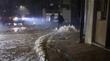 Eine Person geht über eine überflutete Straße im Sturm in Glyfada nahe Athen. Unwetter bringen Starkregen und Orkanböen. Foto: EPA/George Vitsaras