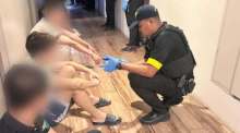 Polizeibeamte kontrollieren mehrere Verdächtige nach der Razzia im Hotel, das ausschließlich chinesische Gäste aufgenommen haben soll. Bild: Central Investigation Bureau (CIB)