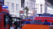 Ein Feuerwehrmann klettert an einem Haus, in dem es gebrannt hat, auf einer Leiter. Bei dem Wohnungsbrand am frühen Montagmorgen sind drei Menschen getötet worden, darunter ein Kind. Foto: David Young/dpa