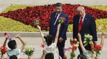 Kinder schwenken chinesische und US-Flaggen während der Begrüßungszeremonie für Donald Trump in Peking. Foto: epa/Maxim Shemetov / Pool