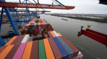 Container werden auf dem Container Terminal Altenwerder (CTA) im Hamburger Hafen umgeschlagen. Der Internationale Währungsfonds (IWF) hat seine Konjunkturprognose für Deutschland erneut nach unten korrigiert. Foto: Marcus Brandt/dpa