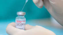 Eine Krankenschwester zieht den Impfstoff des Herstellers Moderna gegen das Coronavirus in einer gestellten Situation mit einer Spritze auf. Foto: Friso Gentsch/dpa