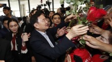Thaksin Shinawatra, umgeben von Anhängern, bei seinem ersten Besuch im Pheu Thai Hauptquartier nach seiner teilweisen Begnadigung. Foto: EPA-EFE/Rungroj Yongrit