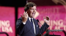 Tucker Carlson spricht bei der Gedenkfeier für den getöteten politischen Aktivisten Charlie Kirk im State Farm Stadium in Arizona. Foto: EPA/Caroline Brehman