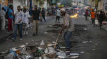 Ein Gemeindemitarbeiter reinigt eine Straße im Stadtteil Petion-Ville in Port-au-Prince, nachdem die Verkäufer gegangen sind. Foto: Odelyn Joseph