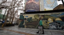 Ein Mann aus dem Iran geht an einem Wandgemälde in der Nähe eines Gebäudes vorbei. Foto: epa/Abedin Taherkenareh