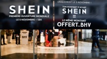 Hinweisschilder bewerben Eröffnungsaktionen im ersten Shein-Store in Paris, dessen Start wegen Kontroversen und Protesten kritisiert wird. Foto: epa/Teresa Suarez