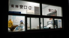 Gesundheitspersonal in Schutzanzügen in einem COVID-19-Testzentrum in Peking. Foto: epa/Mark R. Cristino