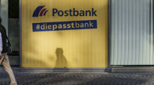 Ein Mann geht an einer Postbank-Filiale vorbei. Foto: Andreas Arnold/dpa