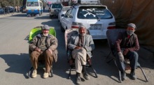 Afghanische Männer sitzen an einem Straßenrand in Kabul. Foto: epa/Samiullah Popal