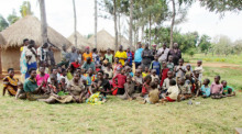 Musa Hasahya (letzte Reihe, r) auf seinem Hof mit seiner Familie. Musa Hasahya hat rund 100 Kinder mit 12 Ehefrauen. Jetzt soll aber Schluss sein, denn der Mann aus Uganda kann seine Großfamilie nicht mehr ernähren. Foto: Henry Wasswa/dpa