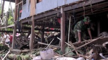Indonesische Soldaten und Rettungskräfte suchen in der Provinz Südsulawesi in den Trümmern eines eingestürzten Hauses nach Opfern einer Sturzflut und eines Erdrutsches. Foto: epa/Abdi