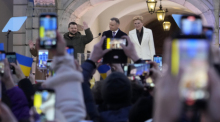 Andrzej Duda (M), Präsident von Polen, steht mit seiner Frau, Agata Kornhauser-Duda, und Wolodymyr Selenskyj, Präsident der Ukraine, auf der Bühne, um Reden zu halten. Foto: Czarek Sokolowski/Ap/dpa