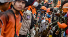 Rettungskräfte tragen die Leiche eines Erdrutschopfers im Dorf Pasirlangu. Starke Regenfälle und extreme Wetterbedingungen hatten Erdrutsche in der Region verursacht. Foto: Dimas Rachmatsyah/Zuma Press Wire/dpa