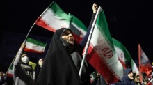Demonstranten schwenken bei einer regierungsnahen Kundgebung in Teheran iranische Nationalflaggen. Foto: EPA/Abedin Taherkenareh