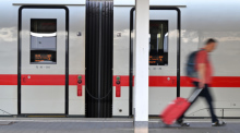 Ein Reisender passiert am Münchner Hauptbahnhof einen ICE-Zug. Nach dem bundesweiten Bahnausfall läuft der Zugverkehr wieder an, Verspätungen bleiben jedoch möglich. Foto: dpa/Peter Kneffel