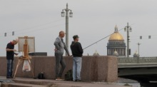 Ein russischer Mann beim Angeln (R) und Malen (L) am Ufer der Newa in St. Petersburg. Foto: epa/Anatoly Maltsev