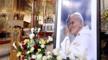 Das Bild des verstorbenen Papstes Johannes Paul II. steht umgeben von Blumen in der Johannes-Basilika in Berlin. Foto: EPA/Bernd Settnik