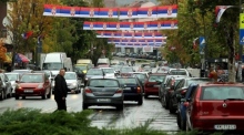 Fahrzeuge bewegen sich auf den mit serbischen Flaggen geschmückten Straßen in Nord-Mitrovica, Kosovo. Foto: epa/Djordje Savic