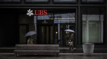 Leute gehen an einem Logo der Schweizer Bank UBS in Zürich vorbei. Foto: epa/Michael Buholzer