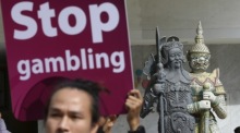 Ein thailändischer Aktivist hält während einer Kampagne gegen Glücksspiel zur Fußball-Weltmeisterschaft 2026 ein Protestplakat in die Höhe. Foto: epa/Narong Sangnak