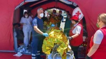 Sanitäter des griechischen Rettungsdienstes (EKAV) und Mitglieder des griechischen Roten Kreuzes helfen Migranten bei ihrer Ankunft im Hafen von Kalamata. Foto: epa/Bougiotis Evangelos