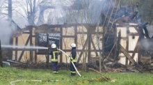 Feuerwehrleute löschen in Wüstefeld bei Rotenburg die noch rauchenden Trümmer des ehemaligen Hofes des «Kannibalen von Rotenburg». Foto: Boris Roessler/dpa