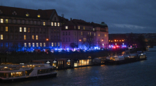 Feuerwehrfahrzeuge und Krankenwagen stehen am Ufer vor der Karlsuniversität. An einer Hochschule in der Prager Innenstadt sollen Schüsse gefallen sein. Foto: Deml Ondøej/Ctk/dpa