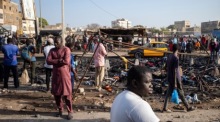 Bewohner betrachten die verkohlten Überreste von Marktständen, die während der Proteste am Vortag in Dakar abgefackelt wurden. Foto: epa/Jerome Favre