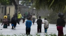 Menschen gehen auf einer überfluteten Straße in der Nähe von Quelimane, als der Sturm Freddy auf Mosambik trifft. Foto: epa/AndrÉ Catueira