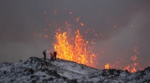 Ein Forscherteam arbeitet am Rand einer Vulkanspalte, aus der während eines Vulkanausbruchs Lava austritt. Foto: epa/Anton Brink