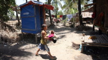 Ein Junge aus Myanmar trägt Kleidung, während er an einer von der Organisation Save the Children gespendeten Toilette im Dorf Thagyarhinoh vorbeigeht. Foto: epa/Nyein Chan Naing