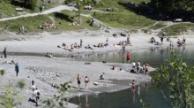 Touristen kühlen sich während der Hitzewelle im Oeschinensee bei Kandersteg im Berner Oberland ab. Foto: epa/Anthony Anex