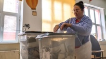 Eine Frau stimmt im Wahllokal der Schule St. Sava in Nordmitrovica ab, wo bei Kommunalwahlen Bürgermeister und Räte neu bestimmt werden. Foto: epa/Georgi Licovski