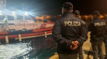 Polizisten warten am Hafenkai auf das Boot mit den Leichen von 8 Migranten in Lampedusa. Foto: epa/Concetta Rizzo