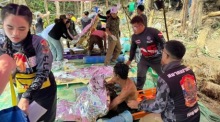 Rettungskräfte versorgen vier laotische Männer mit Rettungsdecken und leisten Erste Hilfe, nachdem sie aus einer überfluteten Höhle in der Provinz Xaysomboun gerettet wurden. Foto: epa/Thailand Rescue Diver/ Facebook Handout