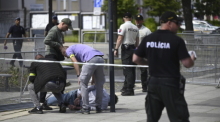 Polizisten nehmen einen Mann fest, nachdem der slowakische Ministerpräsident Fico nach einer Kabinettssitzung in der Stadt Handlova angeschossen und verletzt worden. Foto: Radovan Stoklasa/Tasr Slovakia/ap/dpa