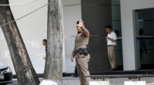 Ein thailändischer Polizeibeamter reagiert während einer Sicherheitspatrouille vor einem Gebäude. Foto: EPA-EFE/Rungroj Yongrit