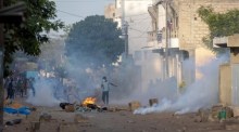 Demonstranten werfen während eines Aufstands in Dakar Steine auf die Polizei. Foto: epa/Jerome Favre