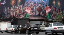 Passanten gehen am Enqelab-Platz in Teheran an einer großflächigen Werbetafel vorbei. Iran und die USA haben ein Friedensabkommen unterzeichnet. Foto: epa/Abedin Taherkenareh