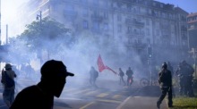 Menschen geraten bei einer Anti-G7-Demonstration in Genf mit der Polizei aneinander. Foto: epa/Jean-christophe Bott