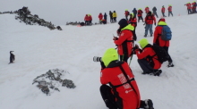 Touristen fotografieren am einen Pinguin in der Antarktis. Immer mehr Influencer posten Clips aus der Antarktis auf Plattformen wie Tiktok. Die Folge: Die unberührte Region im Südpolarmeer erlebt einen Touristenboom. Foto: Ricardo Roura/dpa