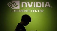 Besucher gehen am Nvidia-Firmenlogo vorbei. Foto: epa/Ritchie B. Tongo