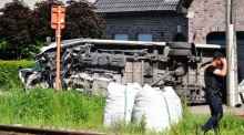 Blick auf einen umgekippten Schulbus, nachdem dieser mit einem Zug am Bahnübergang Vierhuizen in Buggenhout zusammengestoßen war. Foto: Dirk Waem/Belga/dpa