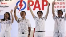 Singapurs künftiger Premierminister Lawrence Wong winkt am Wahlabend mit seinem Team den jubelnden Anhängern zu. Foto: epa/How Hwee Young